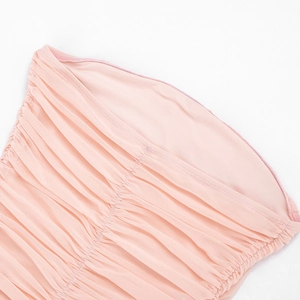 Detail shot of light pink mesh dress featuring elegant ruched pleats and strapless design