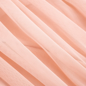 Detailed macro view of light pink mesh fabric showing fine net texture and elegant drape