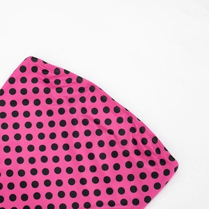 Detailed close-up of pink polka dot fabric with high-quality stitching on bodycon dress