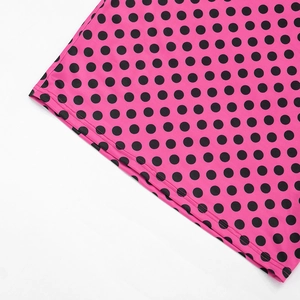Detailed close-up of double-needle hem stitching on pink polka dot mini dress fabric