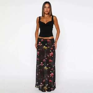 Close-up of semi-transparent black chiffon maxi skirt with floral print and lace hem