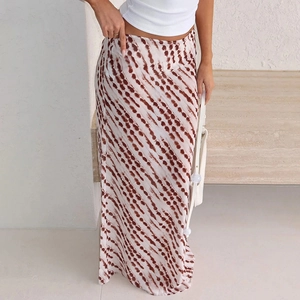 Detail of high-waisted chiffon maxi skirt with brown polka dot print and draped fabric