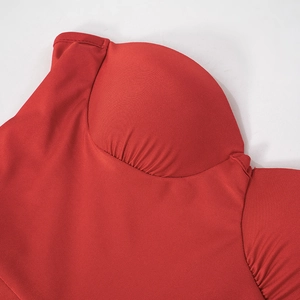 Détail d'un body bustier rouge montrant des bonnets structurés avec texture plissée