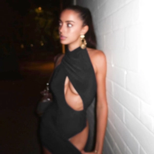Détail d'une robe moulante noire sexy avec décolleté licou croisé et découpes