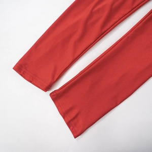 Détail de l'ourlet à double couture sur une combinaison moulante rouge élastique