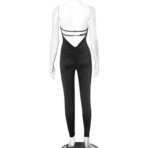 Détail de la couture froncée et du dos nu en V profond sur la combinaison noire