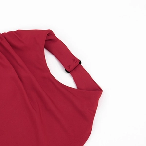 Détail d'une robe rouge à découpes avec anneau noir et texture de tissu raffinée