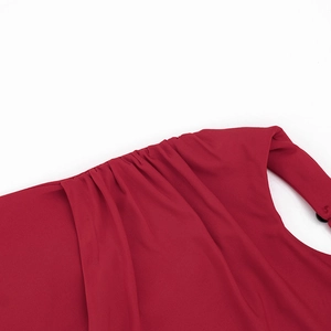 Vue détaillée d'une robe rouge avec des plis élégants et des fronces sur l'épaule