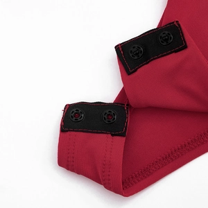 Détail de la robe rouge en maille côtelée avec boutons-pression métalliques sécurisés