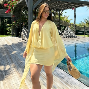 Pale yellow polka dot mini dress with sheer long sleeves and open back for summer resort