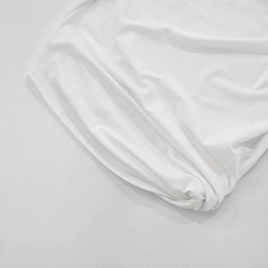 Close-up of white cropped T-shirt featuring double-stitched curved hem and premium knit fabric