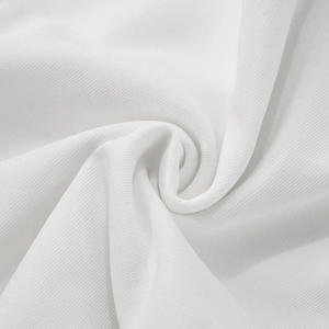Close-up of soft white ribbed fabric texture with fine vertical lines and gentle folds