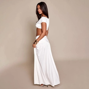 Détail d'un ensemble blanc deux pièces avec crop top sans manches et jupe longue plissée