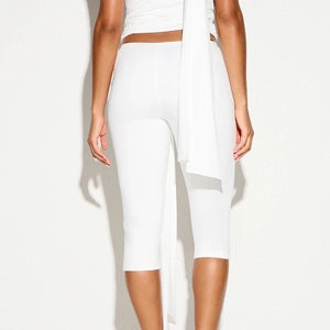 Detail showing the white high-waist slim capri pants with tight-fitting knitted fabric