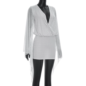 Detailed view of white polka dot mini dress with deep V-neck and split cape sleeves