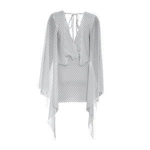 Detail of white polka dot dress featuring a backless design with tie-up neck closure