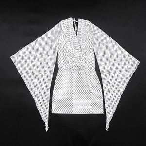 Detail view of polka dot dress featuring dramatic oversized flared mesh sleeves