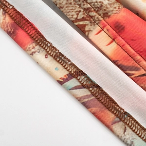 Dettaglio della cucitura overlock sul tessuto del vestito con stampa arancione