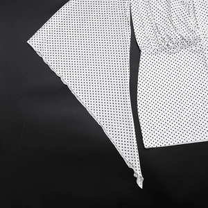 Detail of white polka dot print fabric with pleated texture and wide sleeve design