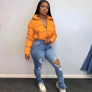 Detail of bright orange puffer jacket featuring a stand collar and zip-up closure