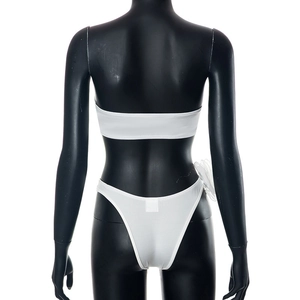 Rear view of white two-piece bikini with bandeau top and high-cut thong on a black mannequin