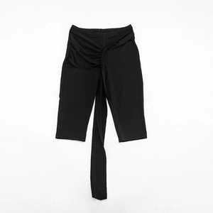 Close-up of black high-waisted shorts with pleated knot and decorative ribbon detail