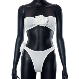 Detail of white two-piece set featuring large 3D fabric roses on tube top and bottoms