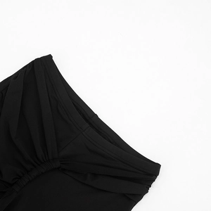 Detailed macro view of ruched fabric and gathered pleats on these black high-waisted pants