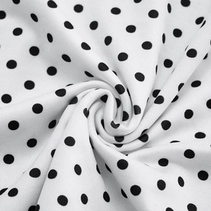 Detailed macro shot of white fabric with black polka dot pattern and soft mesh texture