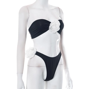 Detailed view of two-piece bikini set with large white 3D floral roses on black fabric