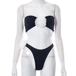 Detail of a black bikini set featuring a 3D white rose on the tube top and high-cut bottom