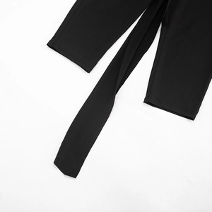 Detailed close-up of high-waisted black trousers with chic waist tie and pleat accents
