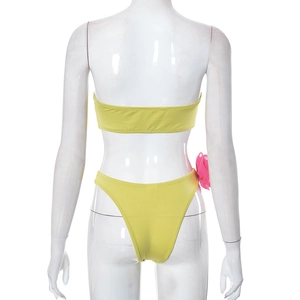 Rear view of neon yellow bikini set featuring a prominent pink floral detail on the bottom