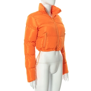 Detail view of the bright orange puffer jacket featuring side zip pockets and drawstring hem