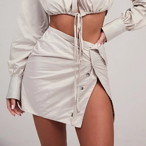 Detail view of high waist slit skirt featuring stylish metal buttons and asymmetric cut