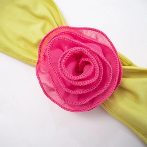Close-up of pink chiffon flower decoration on yellow crop top and bottom set
