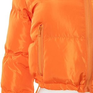 Close-up detail of bright orange puffer jacket showing side zipper pocket and stitching
