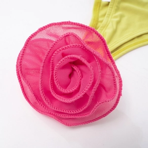 Detail of pink chiffon rose decoration on a bright yellow slim fit summer set