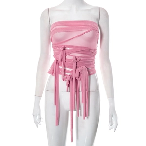 Detail of pink mesh tube top showing intricate crisscross straps and long hanging ribbons