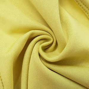 Macro shot of bright yellow knit fabric showing fine texture and double stitching