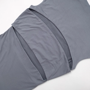 Detalle de vestido sin mangas gris oscuro con abertura lateral y tejido elástico