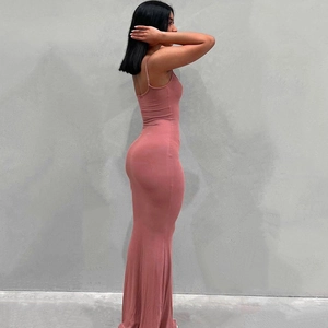Détail de la robe longue rose poudré en maille côtelée montrant la coupe ajustée chic