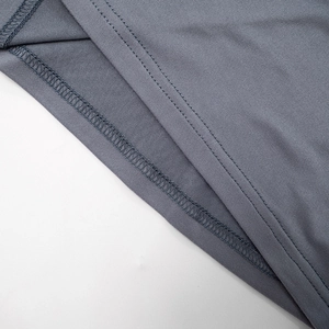 Detalle de costura de doble aguja y textura de tela gris en el vestido ajustado
