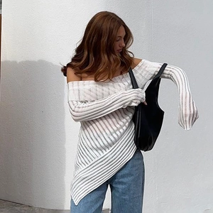 Detail of white off-shoulder long sleeve top featuring sheer striped knit texture