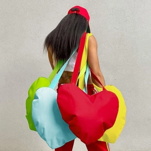 Sacs cabas minimalistes en forme de cœur aux couleurs vives portés par un mannequin