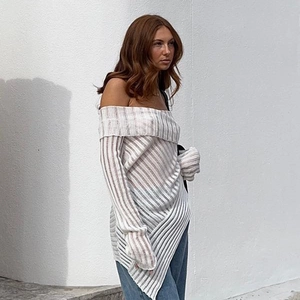 Detail of off-white off-shoulder long sleeve knit top with ribbed texture and asymmetric hem