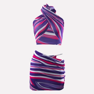 Detailweergave van de haltertop en geplooide rok in paarse abstracte strepen