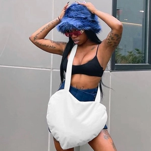 Sac bandoulière blanc en forme de cœur avec large sangle sur fond urbain minimaliste