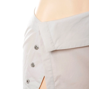 Detail of light gray wrap skirt with silver metal snap buttons and side slit design