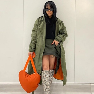 Mannequin portant un grand sac à bandoulière orange en forme de cœur avec tenue d'automne